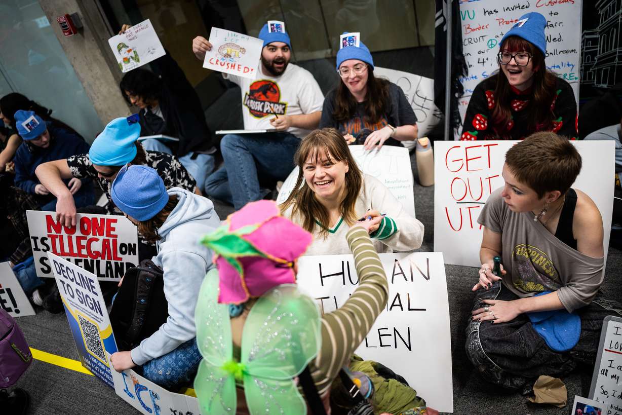 Niyah McConaghie, front center, embraces Abigail Brown, center, during a sit-in against Department of Homeland Security recruitment at a job fair at UVU across from the Sorensen Center Grand Ballroom in Orem on Wednesday.