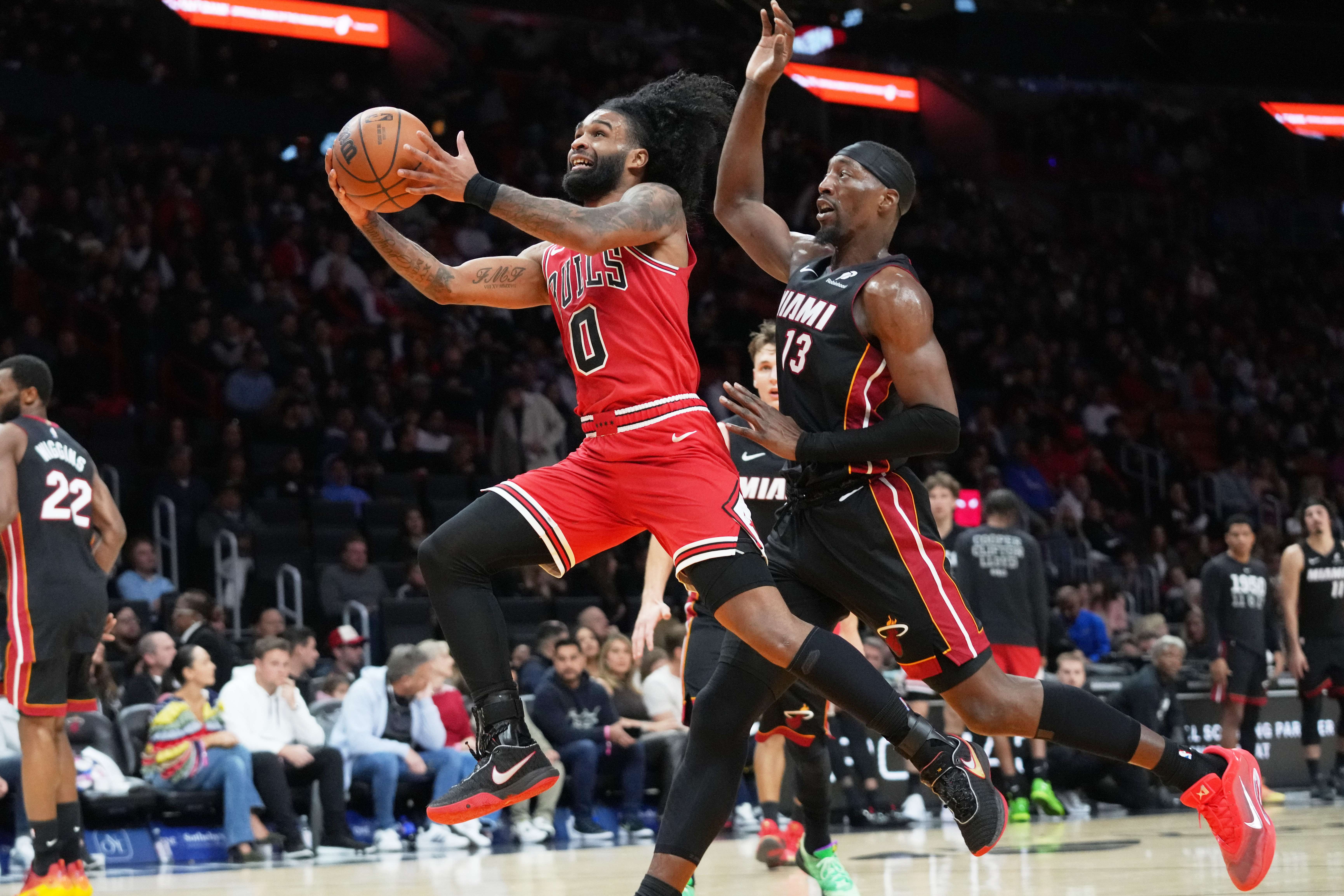 Chicago Bulls guard Coby White (0) drives to the basket as Miami Heat center Bam Adebayo (13) defends during the second half of an NBA basketball game, Sunday, Feb. 1, 2026, in Miami. 