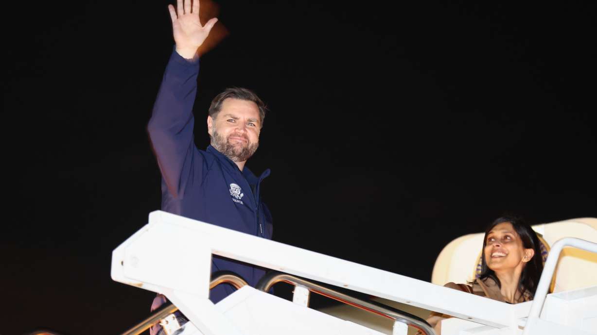 Vice President JD Vance waves as he and second lady Usha Vance board Air Force Two to travel to the Milan Cortina 2026 Winter Olympics in Italy, from Joint Base Andrews, Md., Wednesday.