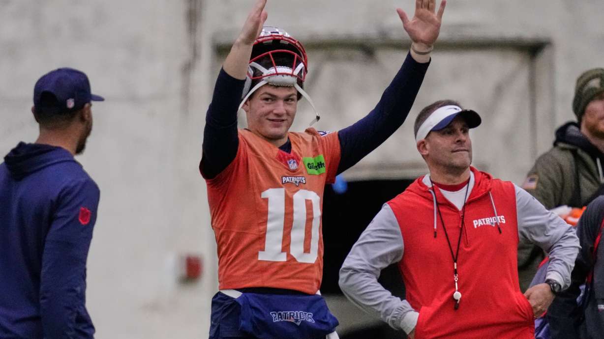 New England Patriots quarterback Drake Maye, left, signals after a field goal while standing with offensive coordinator Josh McDaniels during an NFL football availability, Thursday, Jan. 29, 2026, in Foxborough, Mass.
