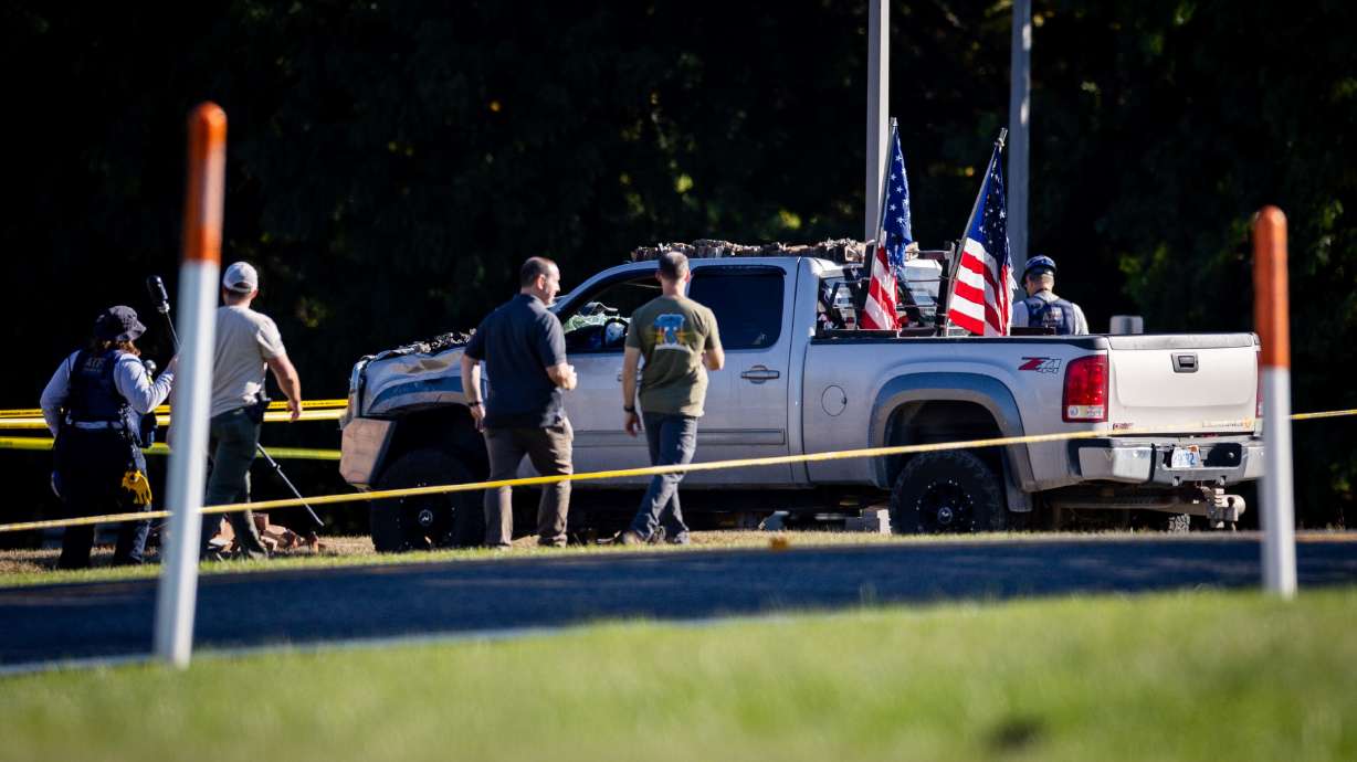 Law enforcement on Sept. 29, after a truck crashed into a meetinghouse of The Church of Jesus Christ of Latter-days Saints where a shooting and fire happened the previous day, in Grand Blanc Township, Mich. The two officers who gunned down the suspect will not face charges, officials said on Thursday.