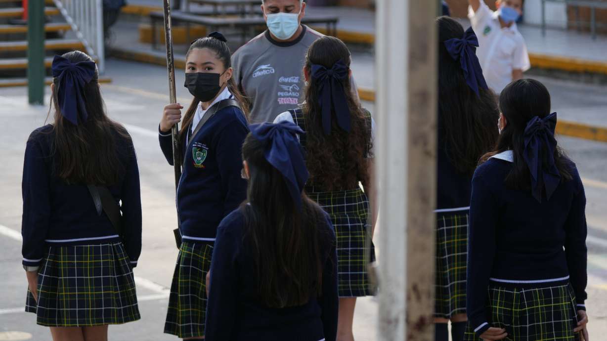 Public school students and teachers wear mandatory face masks amid a measles outbreak, during a ceremony at their school in Guadalajara, Mexico, Thursday, Feb. 5, 2026.