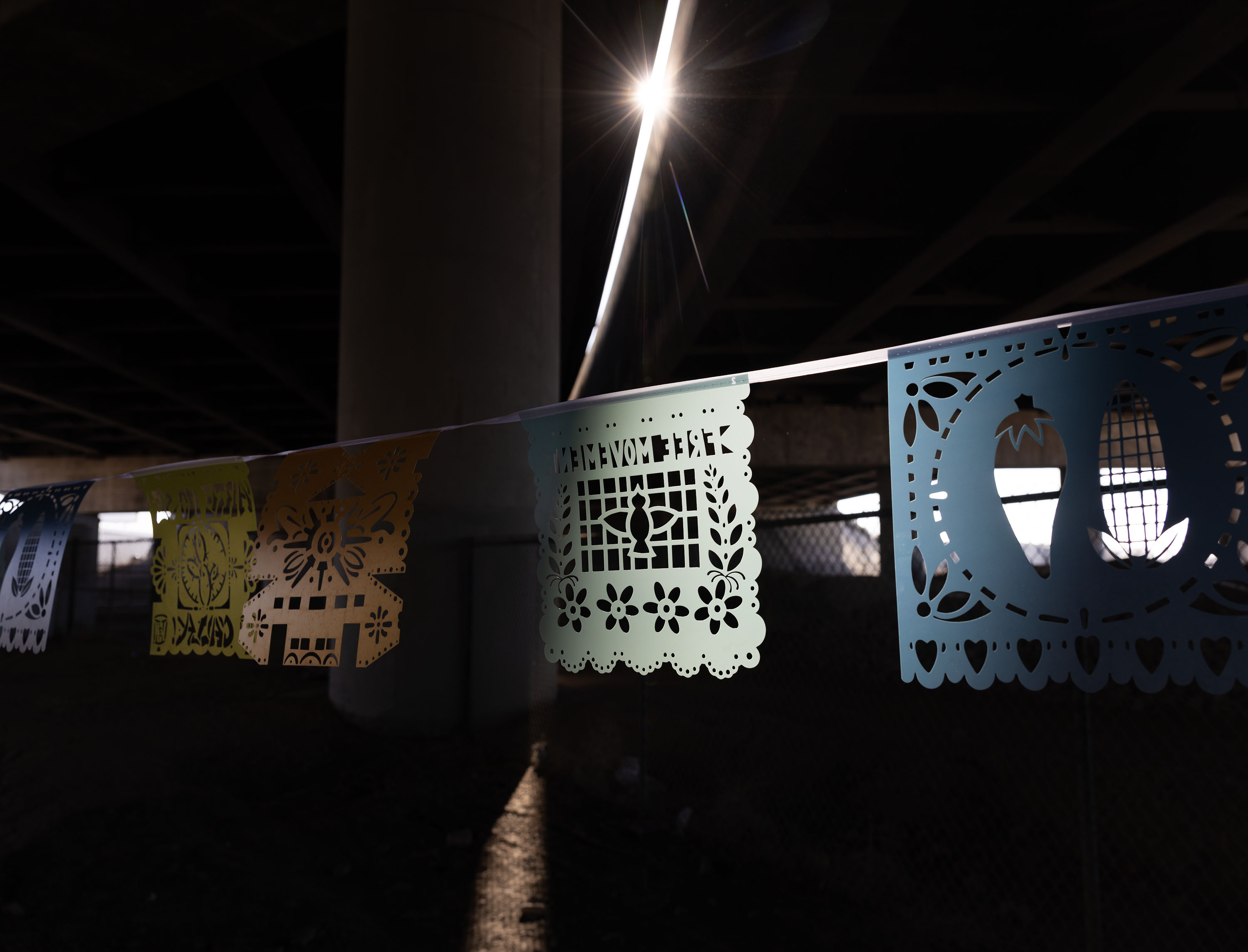 A community-created art installation hangs along the intersection of 900 South and 600 West in Salt Lake City on Thursday. Voces al Vineto is a half-mile of papel picado (perforated paper), a traditional Mexican folk art, stretched across the west-east divide of I-15 and the rail tracks, created by Artes de Mexico en Utah.