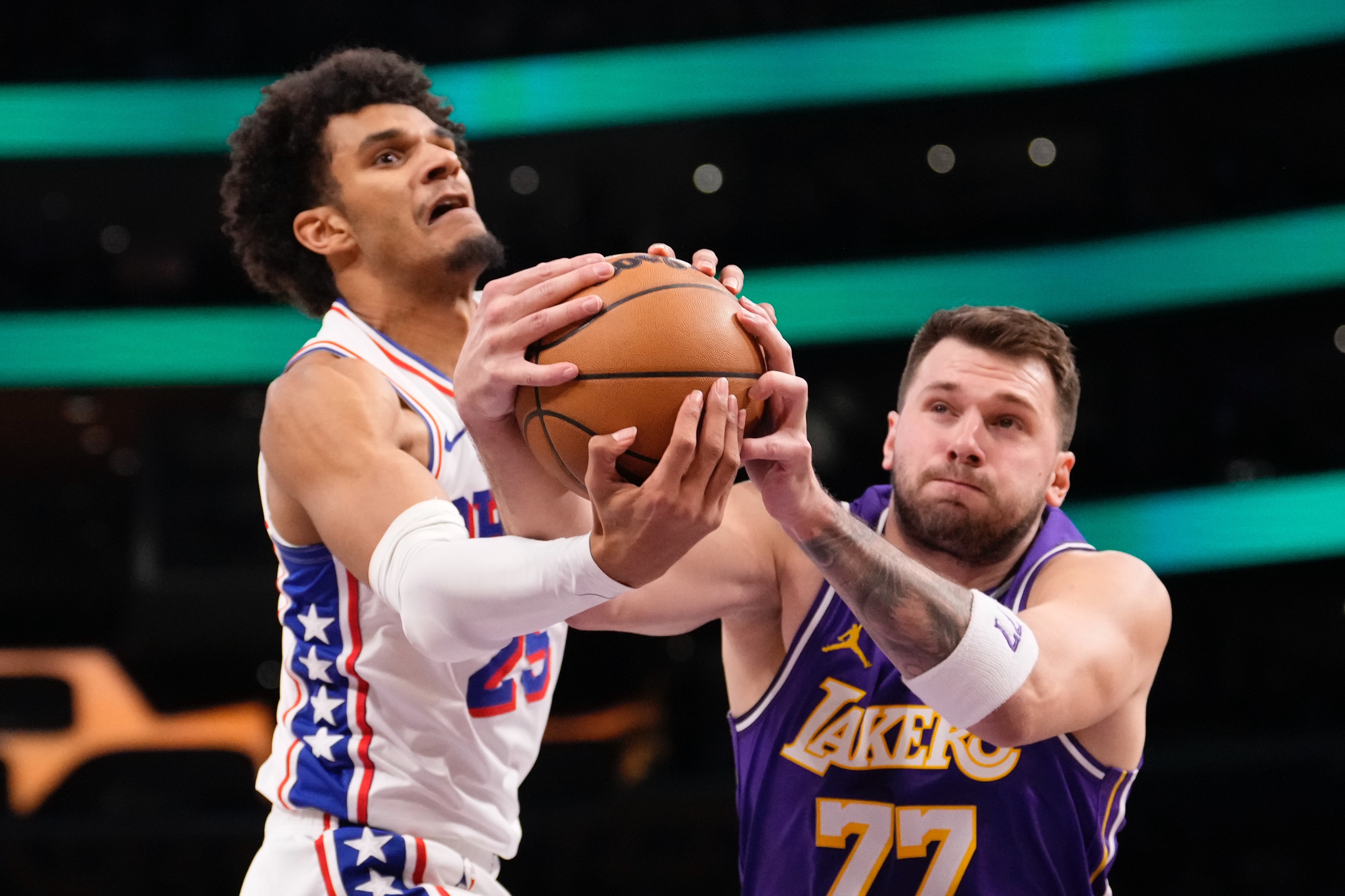 Philadelphia 76ers forward Dominick Barlow, left, and Los Angeles Lakers guard Luka Doncic reach for a rebound during the first half of an NBA basketball game Thursday, Feb. 5, 2026, in Los Angeles. 