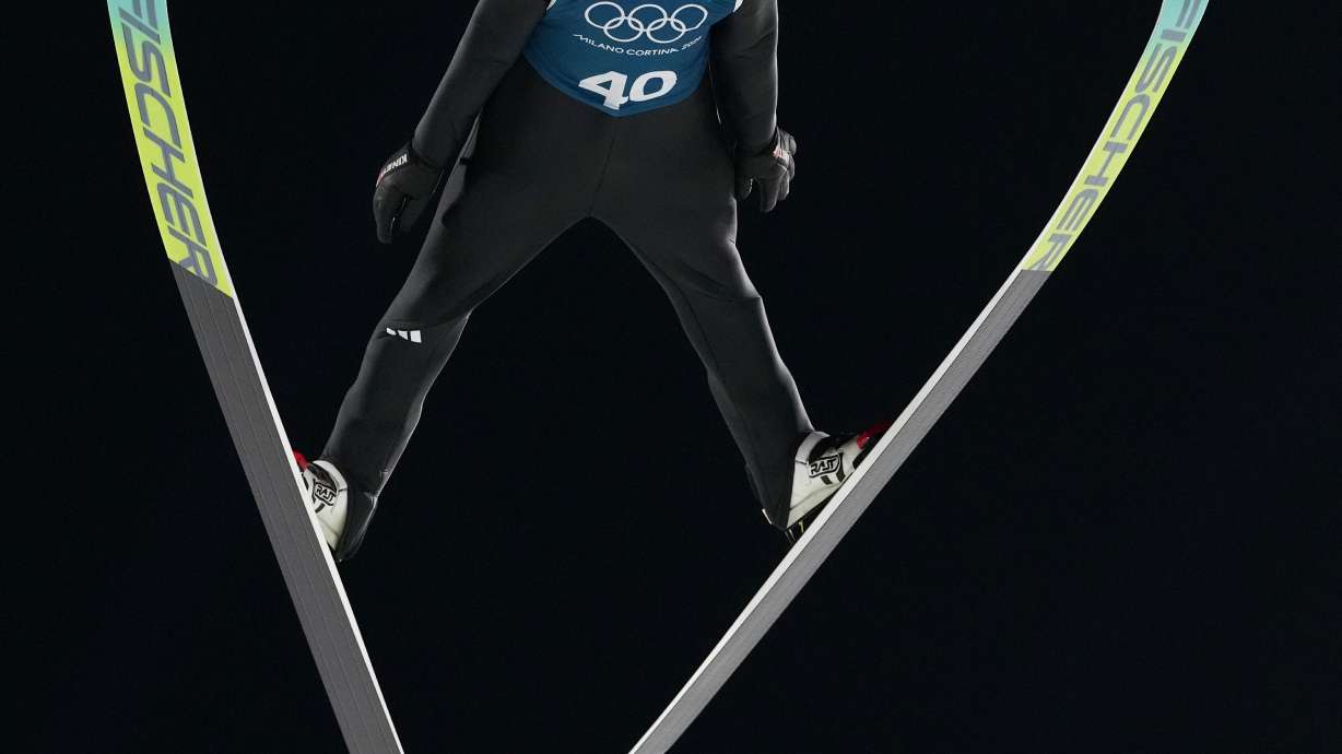 An athlete soars through the air during a ski jumping, men's normal hill, training session,at the 2026 Winter Olympics, in Predazzo, Italy, Thursday, Feb. 5, 2026.