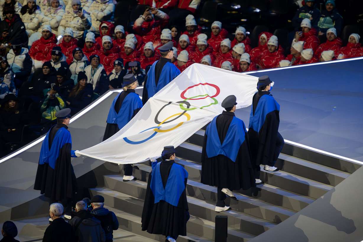 The Olympic flag is carried at the opening ceremonies for the 2026 Milan Cortina Winter Olympics in Milan, Italy, on Friday. The ceremony was a celebration of Italy with a pointed call for peace.