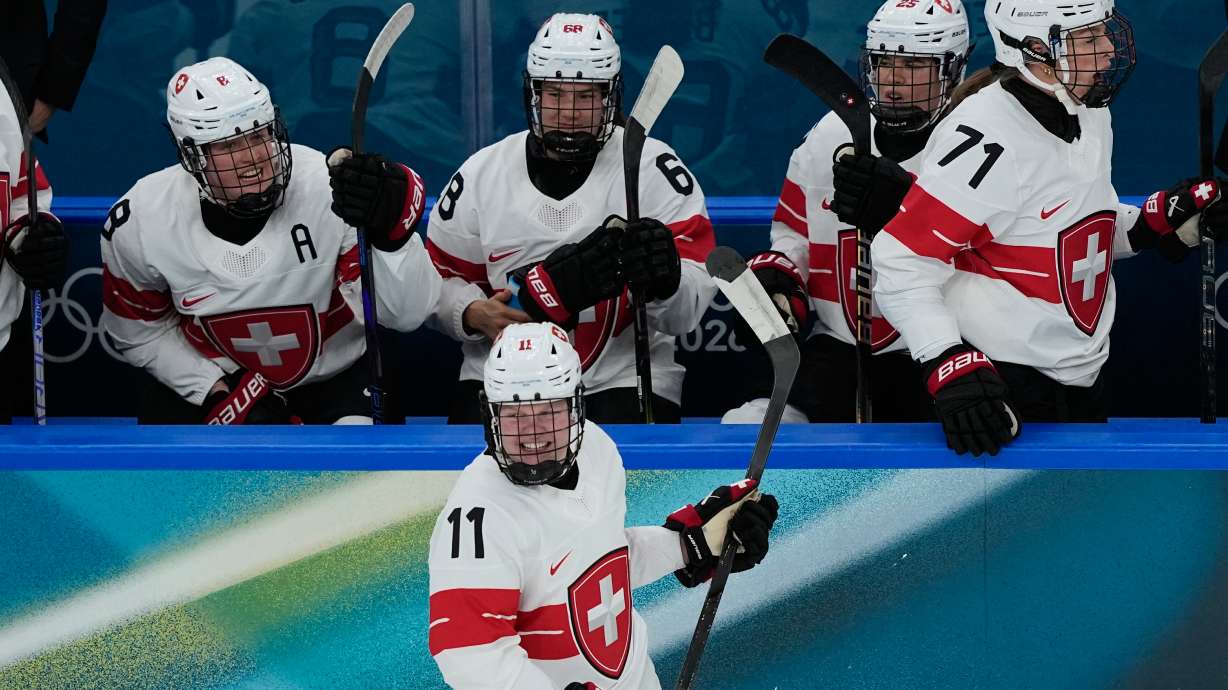 Switzerland's Laura Zimmermann, center, celebrates after scoring her side's opening goal during a preliminary round match of women's ice hockey between Switzerland and Czechia at the 2026 Winter Olympics, in Milan, Italy, Friday, Feb. 6, 2026.