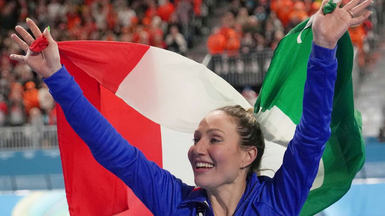 Gold medallist Francesca Lollobrigida of Italy celebrates with the Italian flag after the women's 3,000 meters speedskating race at the 2026 Winter Olympics, in Milan, Italy, Saturday, Feb. 7, 2026.