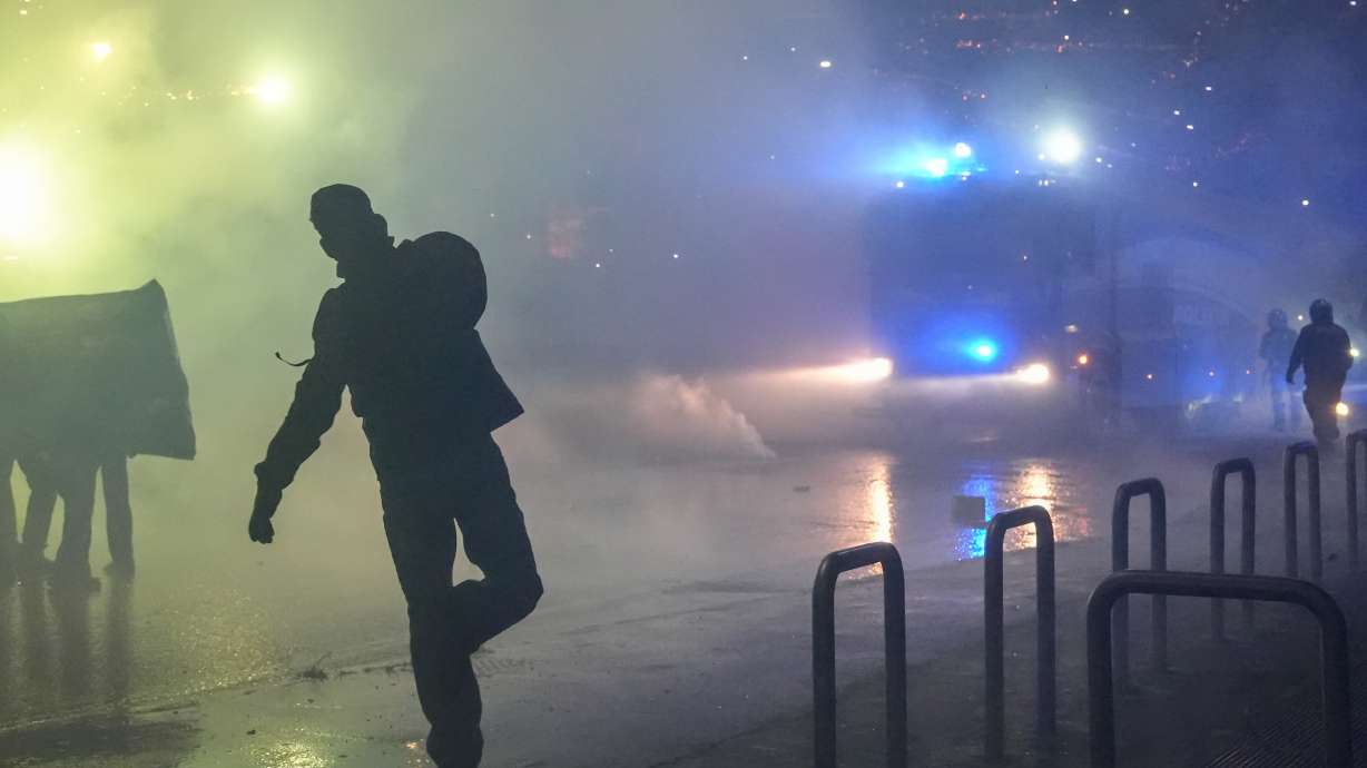 Demonstrators face riot police during a protest against the Milan-Cortina 2026 Olympics, in Milan, Italy, Saturday Feb. 7, 2026.