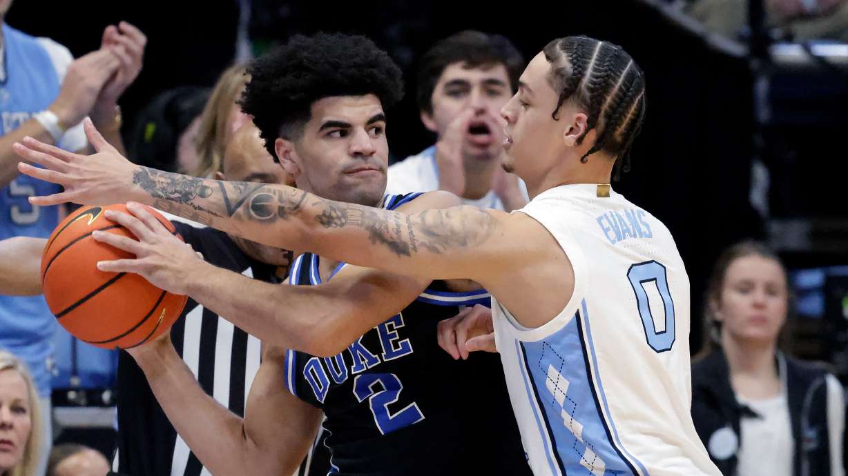 Duke guard Cayden Boozer (2) looks to pass the ball as North Carolina guard Kyan Evans (0) defends during the first half of an NCAA college basketball game Saturday, Feb. 7, 2026, in Chapel Hill, N.C.