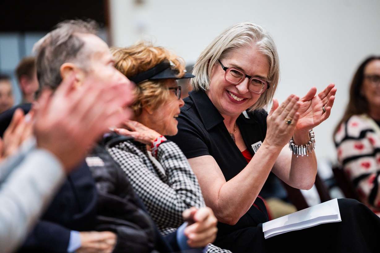Gretchen Dietrich, executive director of the Utah Museum of Fine Arts, right, claps as people involved in the installation of Robert Indiana's "LOVE" sculpture are recognized inside the Utah Museum of Fine Arts after viewing the sculpture on the south lawn in Salt Lake City on Saturday. Dietrich especially credited University President Taylor Randall and his team for the installation.