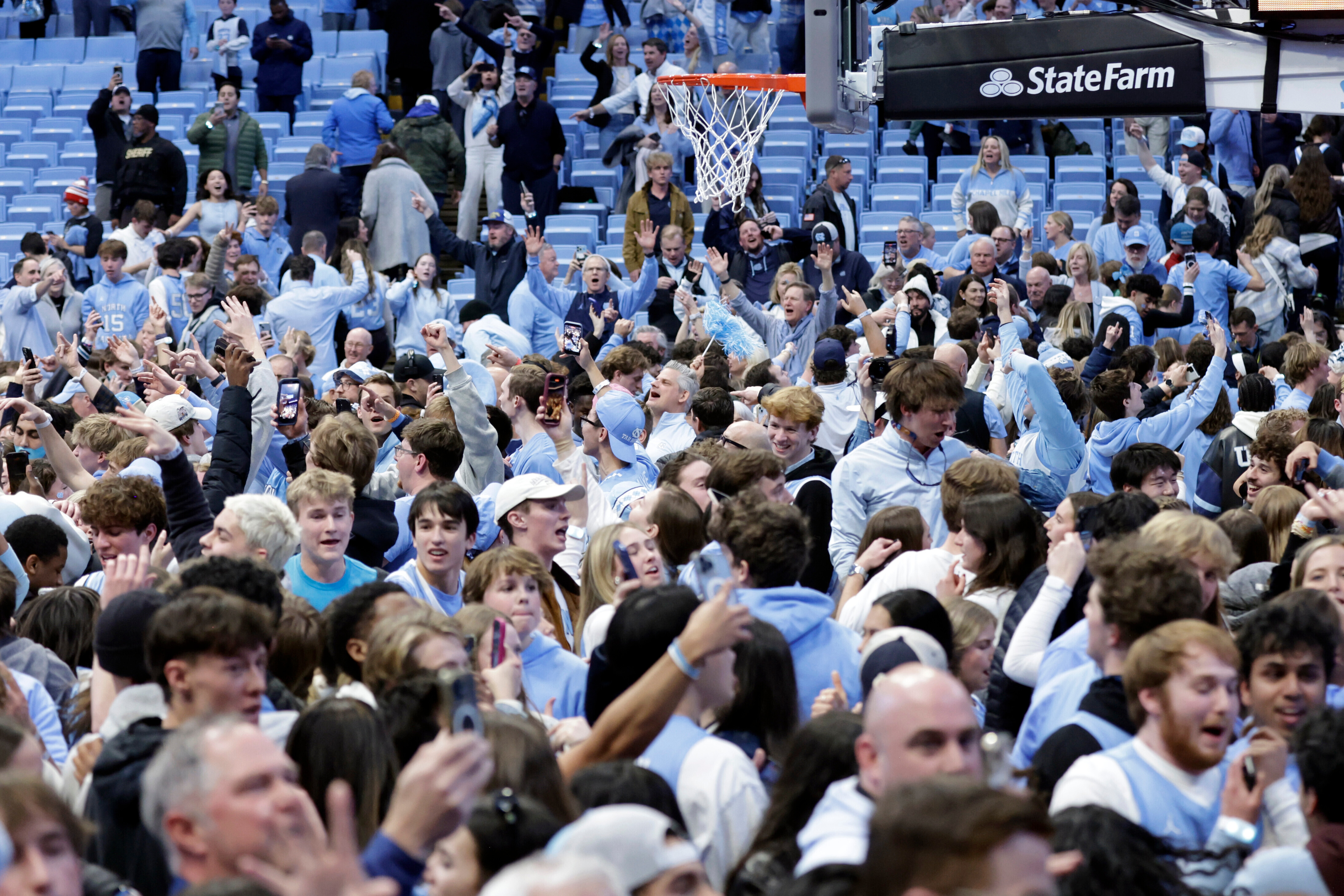 North Carolina fans take the floor and celebrate after the team defeated Duke in the final seconds of an NCAA college basketball game Saturday, Feb. 7, 2026, in Chapel Hill, N.C. 