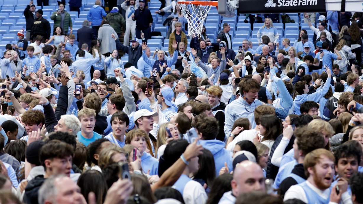 North Carolina fans take the floor and celebrate after the team defeated Duke in the final seconds of an NCAA college basketball game Saturday, Feb. 7, 2026, in Chapel Hill, N.C.
