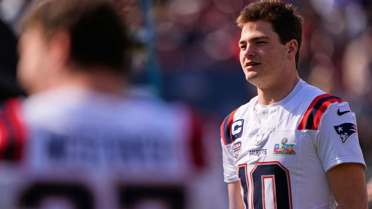 New England Patriots quarterback Drake Maye waits to be in a group photo at their practice venue for the Super Bowl 60 NFL football game against the Seattle Seahawks, Saturday, Feb. 7, 2026, in Stanford, Calif.