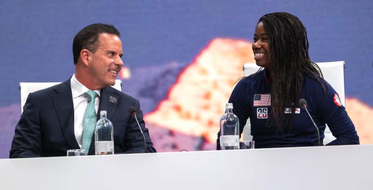 Brad Wilson, CEO of the Organizing Committee for the 2034 Olympic and Paralympic Winter Games, looks over at Olympic Speed Skater Erin Jackson, after she spoke to the IOC in Milan on Tuesday.
