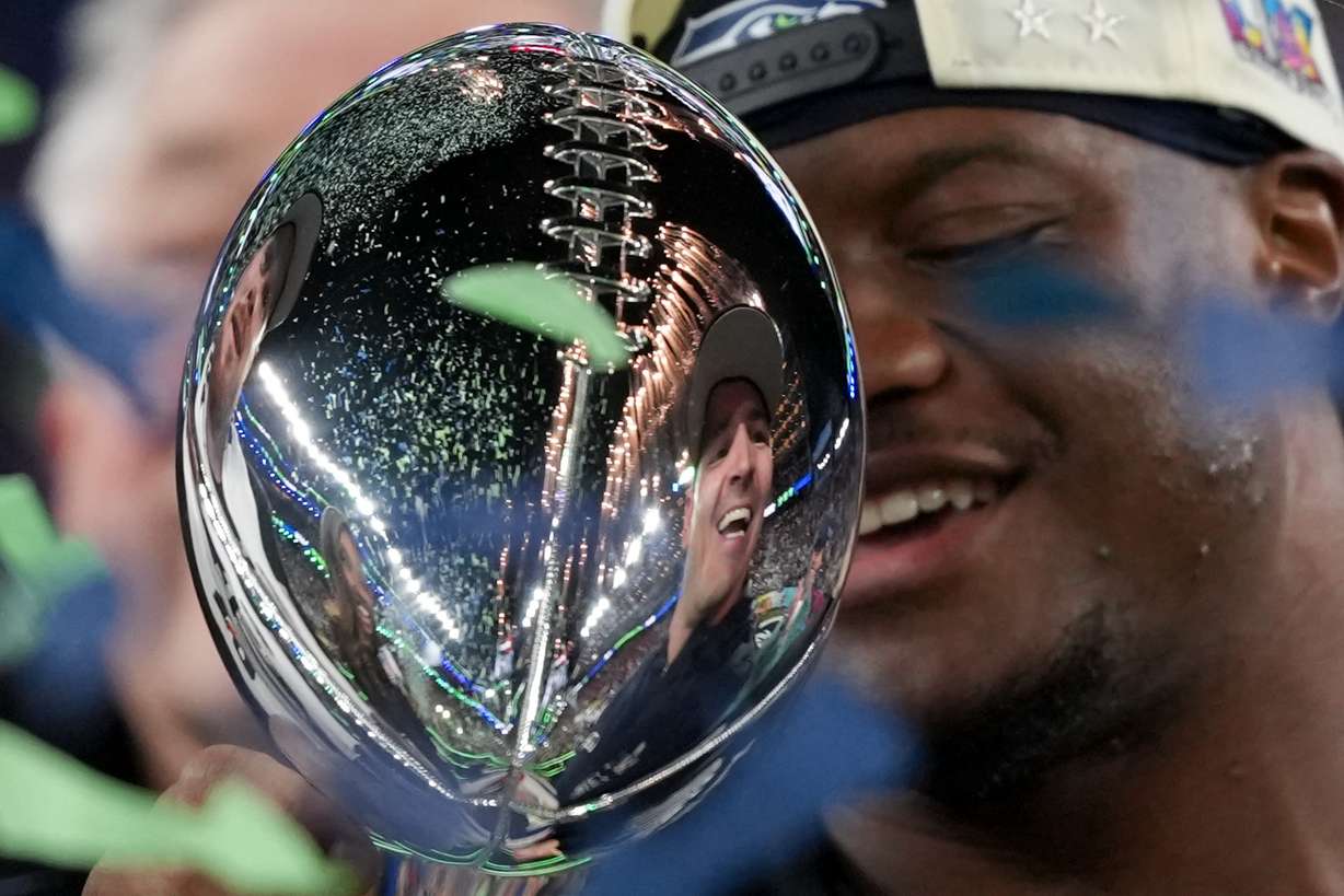 Seattle Seahawks head coach Mike MacDonald is reflected in the Lombardi Trophy after a win over the New England Patriots in the NFL Super Bowl 60 football game Sunday, Feb. 8, 2026, in Santa Clara, Calif.