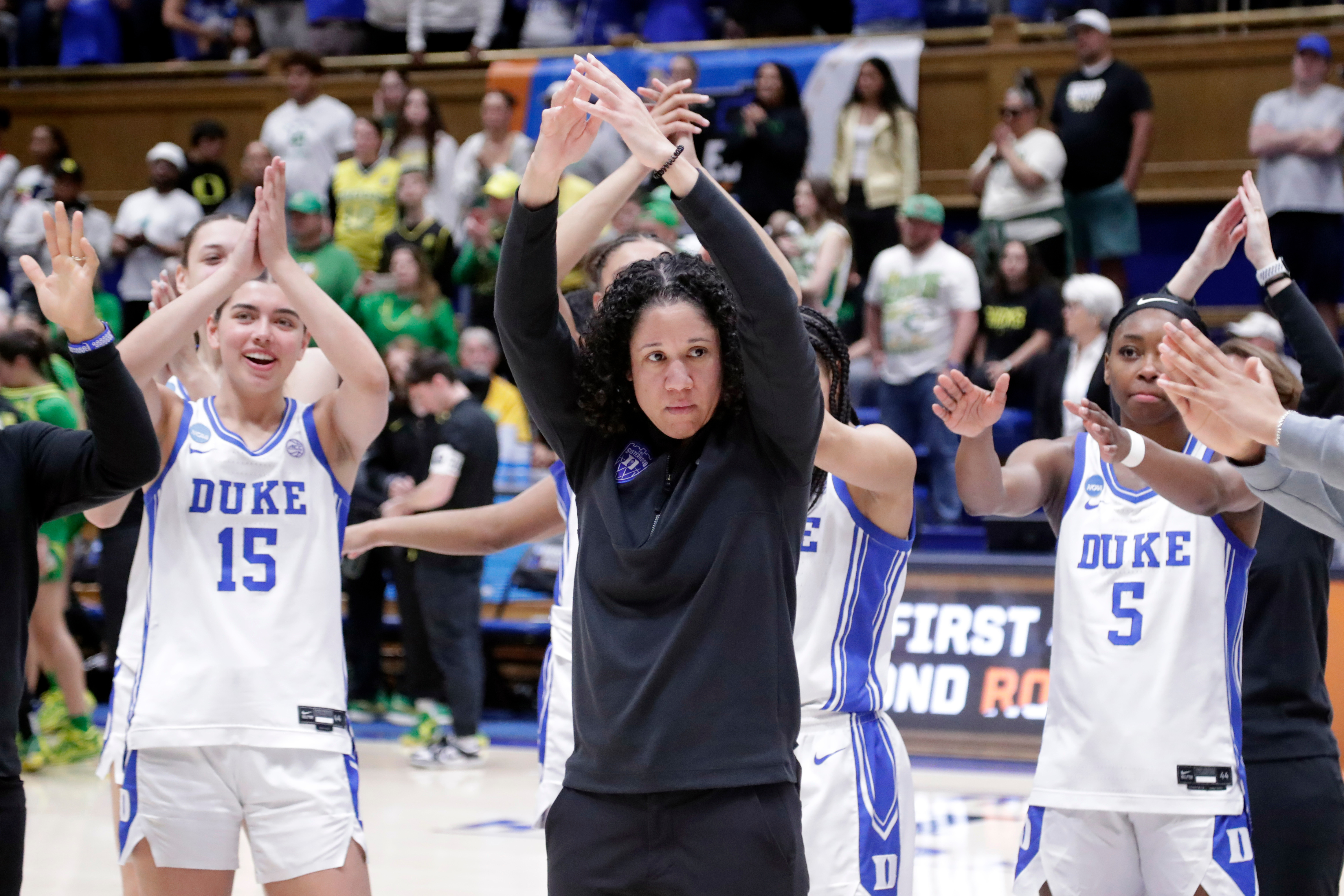 FILE - Duke head coach Kara Lawson, center, and her players celebrate after they defeated Oregon in the second round of the NCAA college basketball tournament Sunday, March 23, 2025, in Durham N.C. 