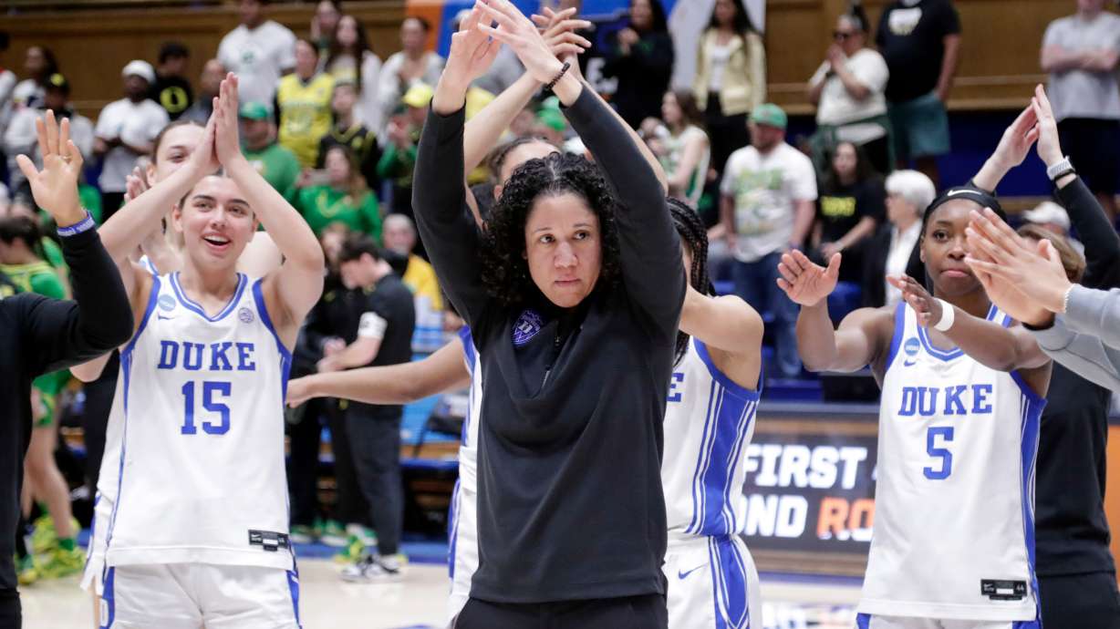 FILE - Duke head coach Kara Lawson, center, and her players celebrate after they defeated Oregon in the second round of the NCAA college basketball tournament Sunday, March 23, 2025, in Durham N.C.