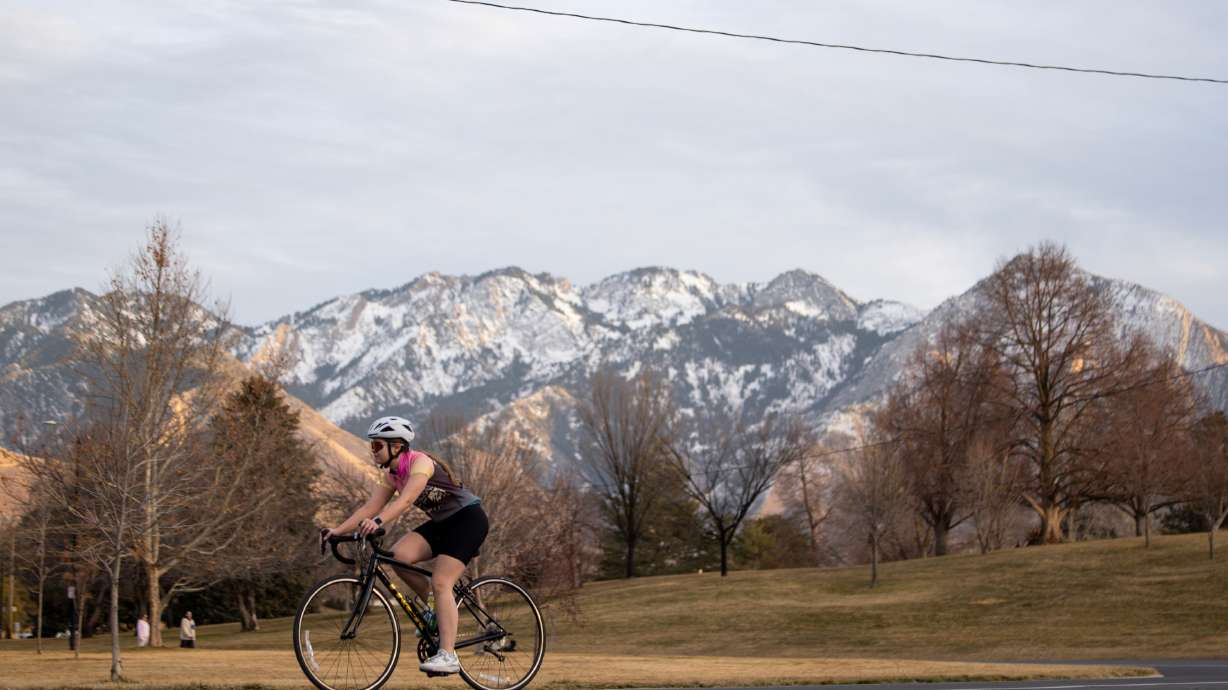 A cyclist rides through Sugar House Park in Salt Lake City on Sunday. An incoming storm system should help break up a dry stretch in the state this week, but it's unclear how much it will help the state's record-low snowpack.