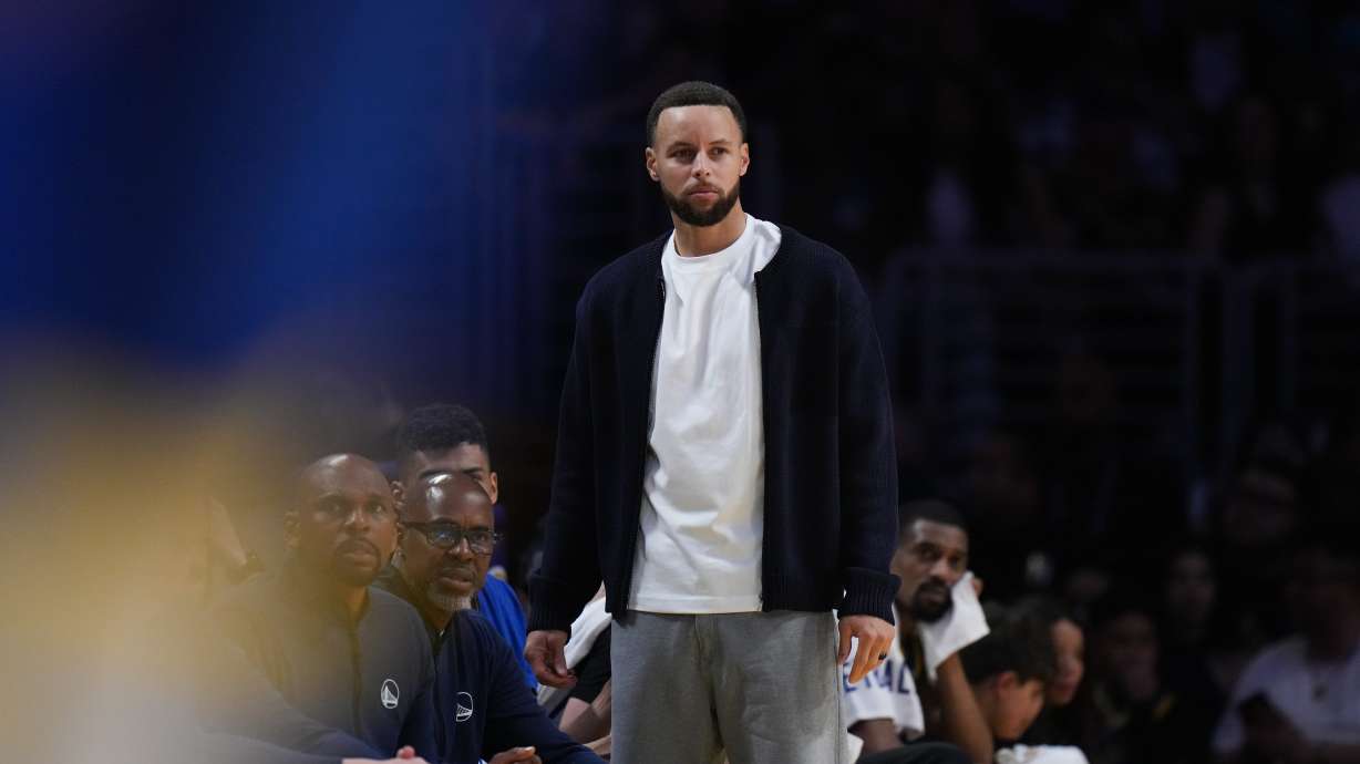Golden State Warriors guard Stephen Curry watches action from the bench during the first half of an NBA basketball game against the Los Angeles Lakers Saturday, Feb. 7, 2026, in Los Angeles.