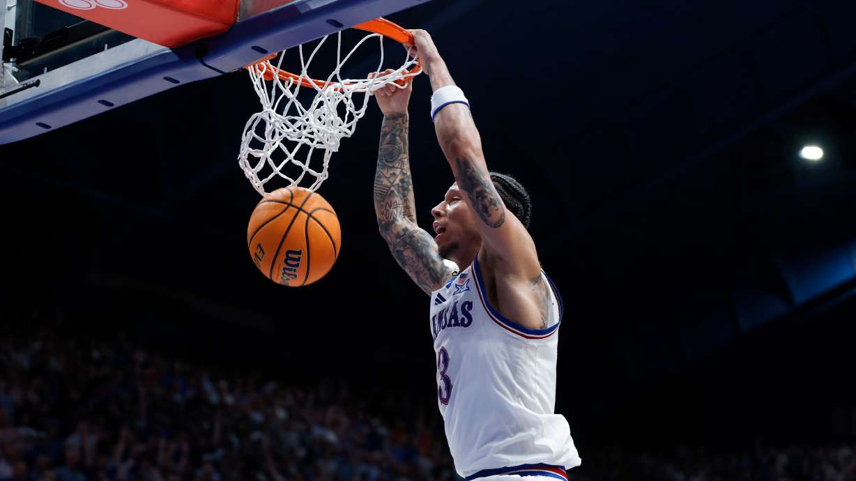 Kansas guard Tre White dunks during the first half of an NCAA college basketball game against Arizona, Monday, Feb. 9, 2026, in Lawrence, Kan.
