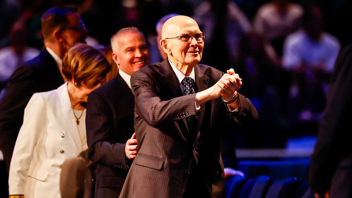 President Dallin H. Oaks of The Church of Jesus Christ of Latter-day Saints, accompanied by his wife, Kristen, and Brigham Young University President C. Shane Reese, greets students and faculty in the Marriott Center in Provo on Tuesday.