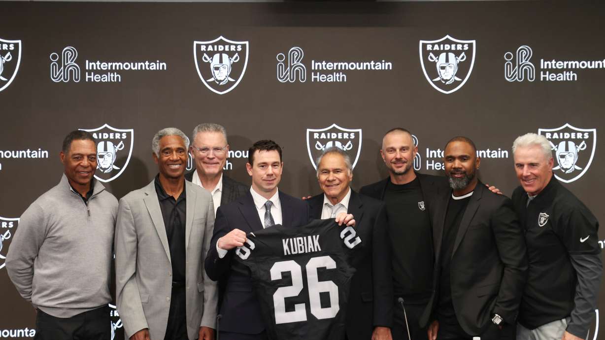 Las Vegas Raiders new head coach Klint Kubiak, fourth from left, poses with from left, Marcus Allen, Mike Haynes, Howie Long, Jim Plunkett, general manager John Spytek and Charles Woodson during an introductory news conference at the NFL football team's training facility Tuesday, Feb. 10, 2026, in Henderson, Nev.