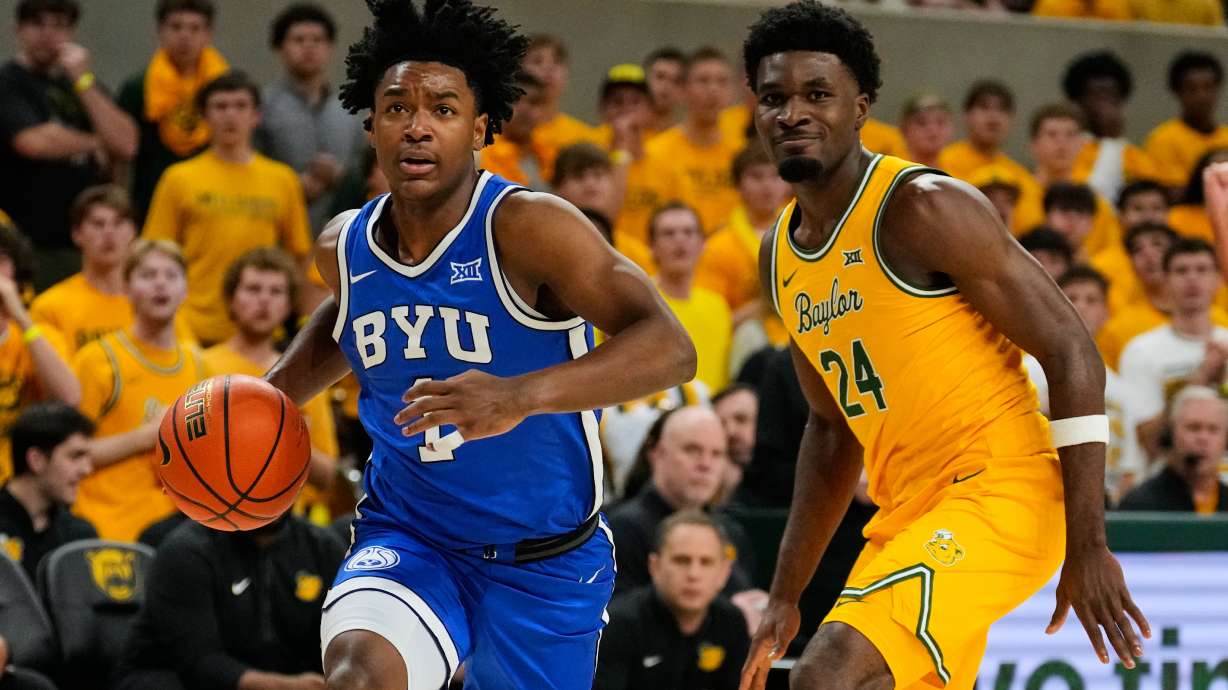 BYU guard Robert Wright III (1) drives to the basket after getting past Baylor guard Tounde Yessoufou (24) in the first half of an NCAA college basketball game Tuesday, Feb. 10, 2026, in Waco, Texas.