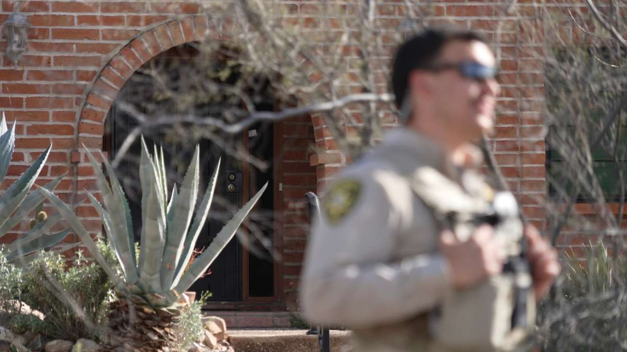 A member of the Pima County Sheriff's Department stands in front of the house of Nancy Guthrie, the missing mother of "Today" show host Savannah Guthrie, Tuesday, in Tucson, Ariz. The department said it detained a person for questioning.