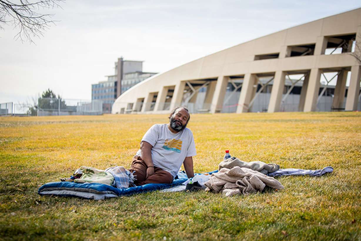 Jacob Myra Omar, a person experiencing homelessness, sits outside the Salt Lake City Public Library before going inside the library to take a nap in Salt Lake City on Feb. 3, 2026.