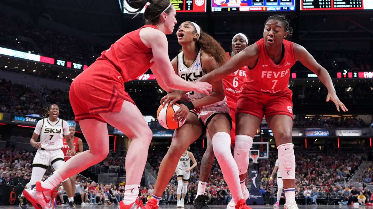 FILE - Indiana Fever guard Caitlin Clark, left, fouls Chicago Sky forward Angel Reese, center, during the second half an WNBA basketball game in Indianapolis, Saturday, May 17, 2025.