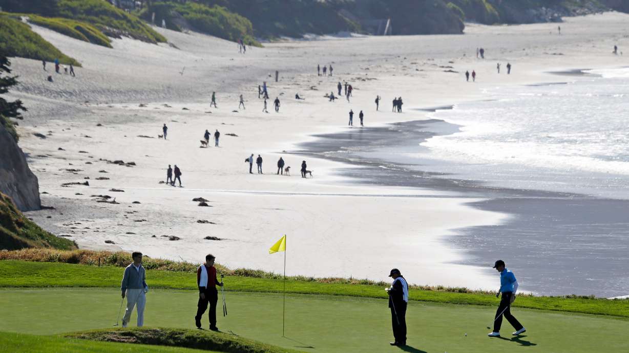 FILE - In this Feb. 6, 2013, file photo, Roberto Castro, right, walks to his ball on the tenth green of the Pebble Beach Golf Links during a practice round of the AT&T Pebble Beach Pro-Am golf tournament in Pebble Beach, Calif. It's played on one of the world's most picturesque courses on the first weekend after the Super Bowl, offering magnificent views of the Monterey Peninsula to golf fans still digging out from the snow.