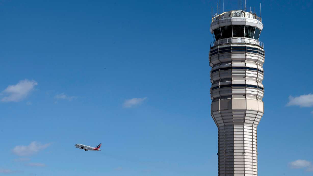 An airplane takes off behind the control tower at Ronald Reagan Washington National Airport, on the anniversary of the Potomac River mid-air collision between an American Airlines passenger plane and an Army Blackhawk helicopter, Thursday, Jan. 29, 2026, in Arlington, Va.