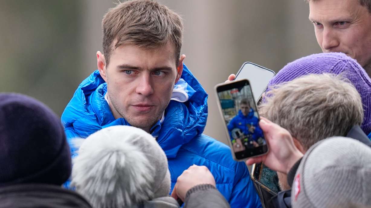 Ukraine's Vladyslav Heraskevych, left, talks to the media during a men's skeleton training session at the 2026 Winter Olympics, in Cortina d'Ampezzo, Italy, Wednesday, Feb. 11, 2026.