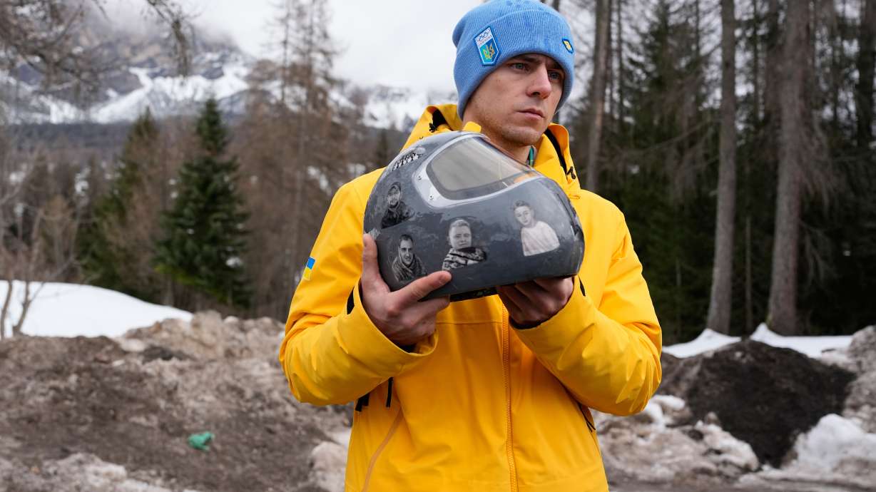 Ukrainian skeleton athlete Vladyslav Heraskevych holds his crash helmet as he stands outside the sliding center at the 2026 Winter Olympics, in Cortina d'Ampezzo, Italy, Thursday, Feb. 12, 2026.