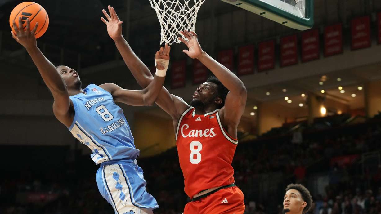 North Carolina forward Caleb Wilson (8) drives to the basket as Miami center Ernest Udeh Jr. (8) defends during the first half of an NCAA college basketball game, Tuesday, Feb. 10, 2026, in Coral Gables, Fla.