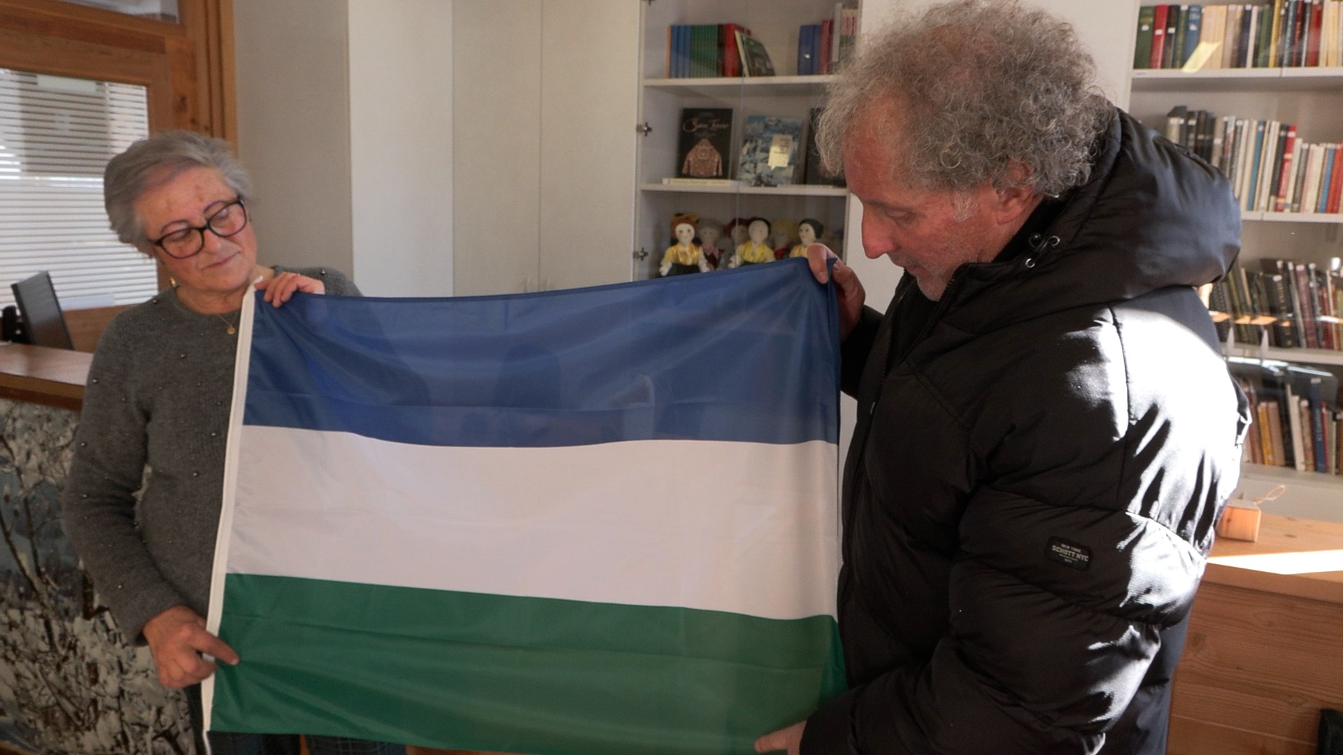 Elsa Zardyny holds a flag of the Ladin people in Cortina, Italy, Thursday. Zardyny said the Ladin people "have a long history and tale to tell."