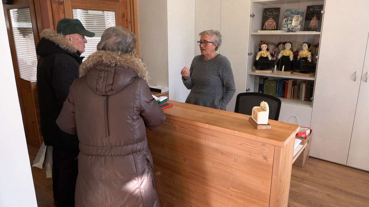 Elsa Zardyny talks with a couple about the Ladin people in Cortina, Italy, Thursday. Zardyny said she is seeking recognition from the Milan Cortina Olympic Committee for the Ladin people as part of Italy.
