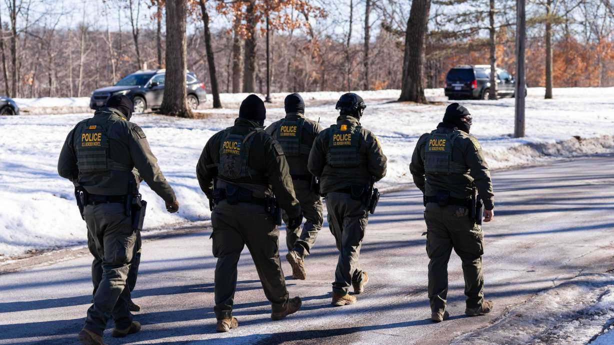 U.S. Border Patrol officers walk along a street in Minneapolis, Wednesday, Jan. 14. Federal authorities have opened a criminal probe into whether two immigration officers lied under oath about a shooting in Minneapolis last month.