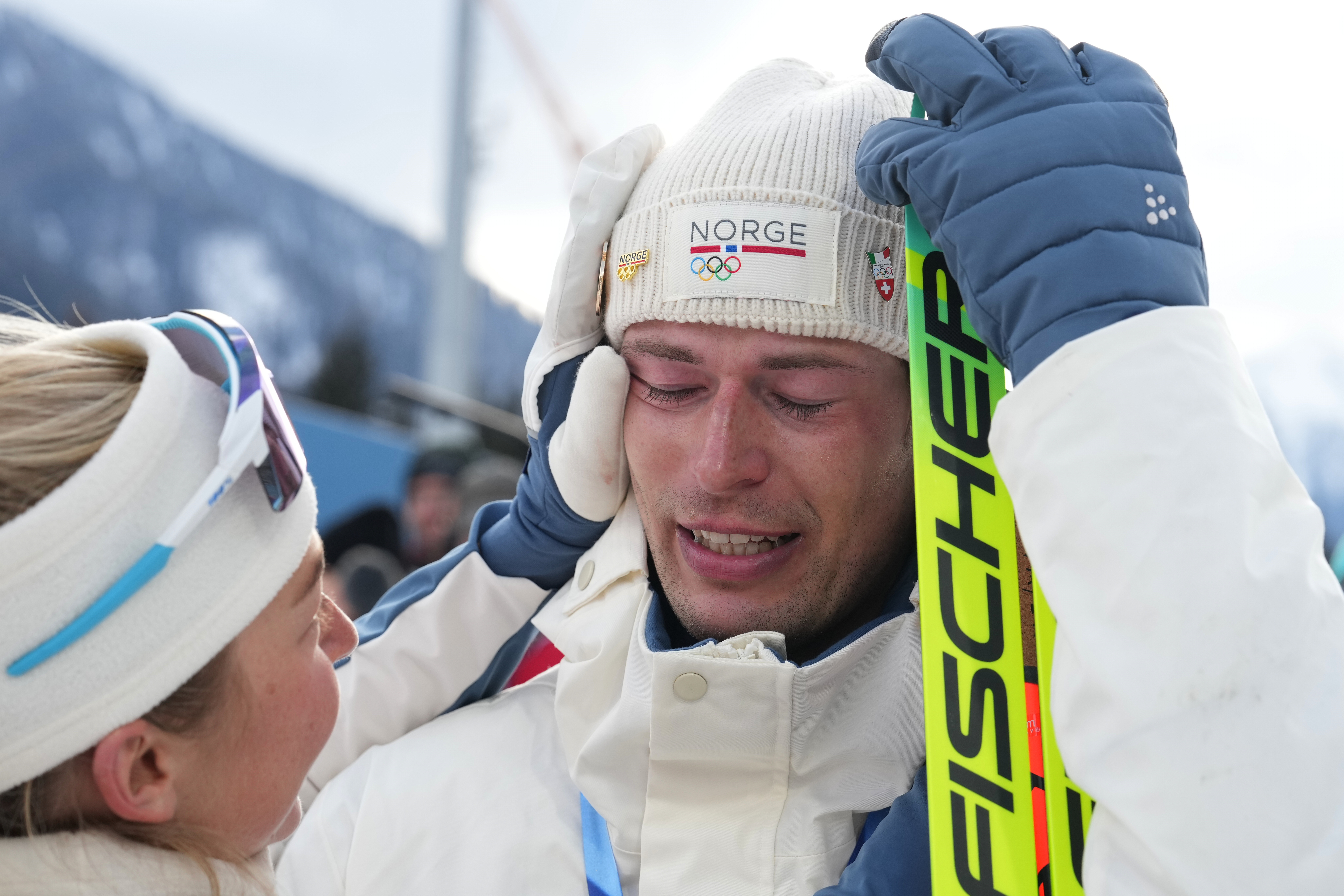 ADDS NAME OF TEAMMATE - Sturla Holm Laegreid, of Norway, reacts after he won bronze as teammate Ingrid Landmark Tandrevold comforts him after the men's 20-kilometer individual biathlon race at the 2026 Winter Olympics in Anterselva, Italy, Tuesday, Feb. 10, 2026. 