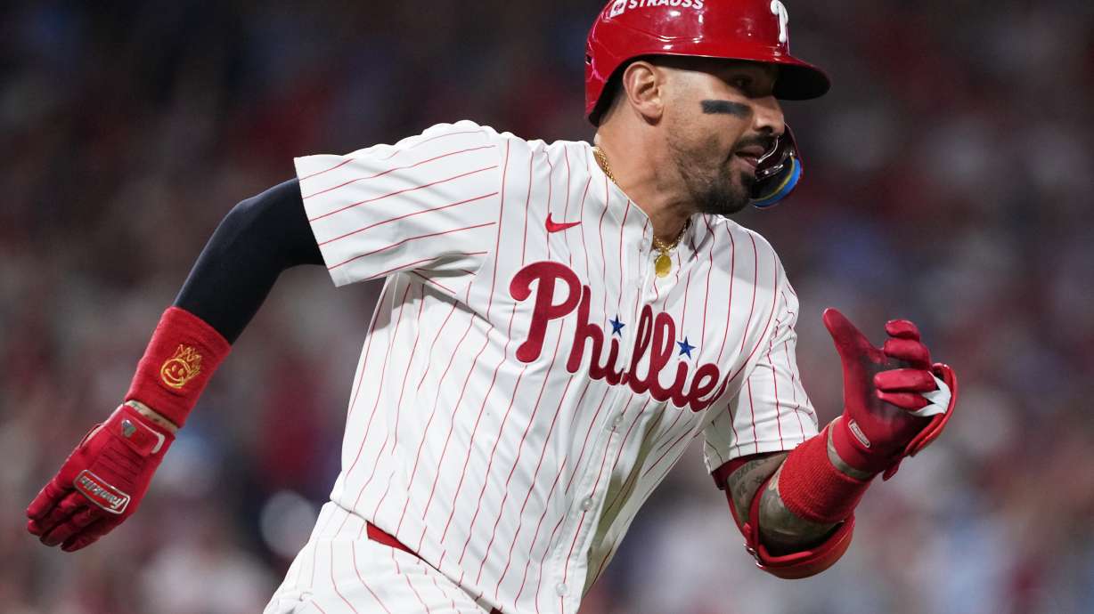FILE - Philadelphia Phillies' Nick Castellanos runs after hitting a double to score Alec Bohm and J.T. Realmuto during the ninth inning in Game 2 of baseball's National League Division Series against the Los Angeles Dodgers, Oct. 6, 2025, in Philadelphia.