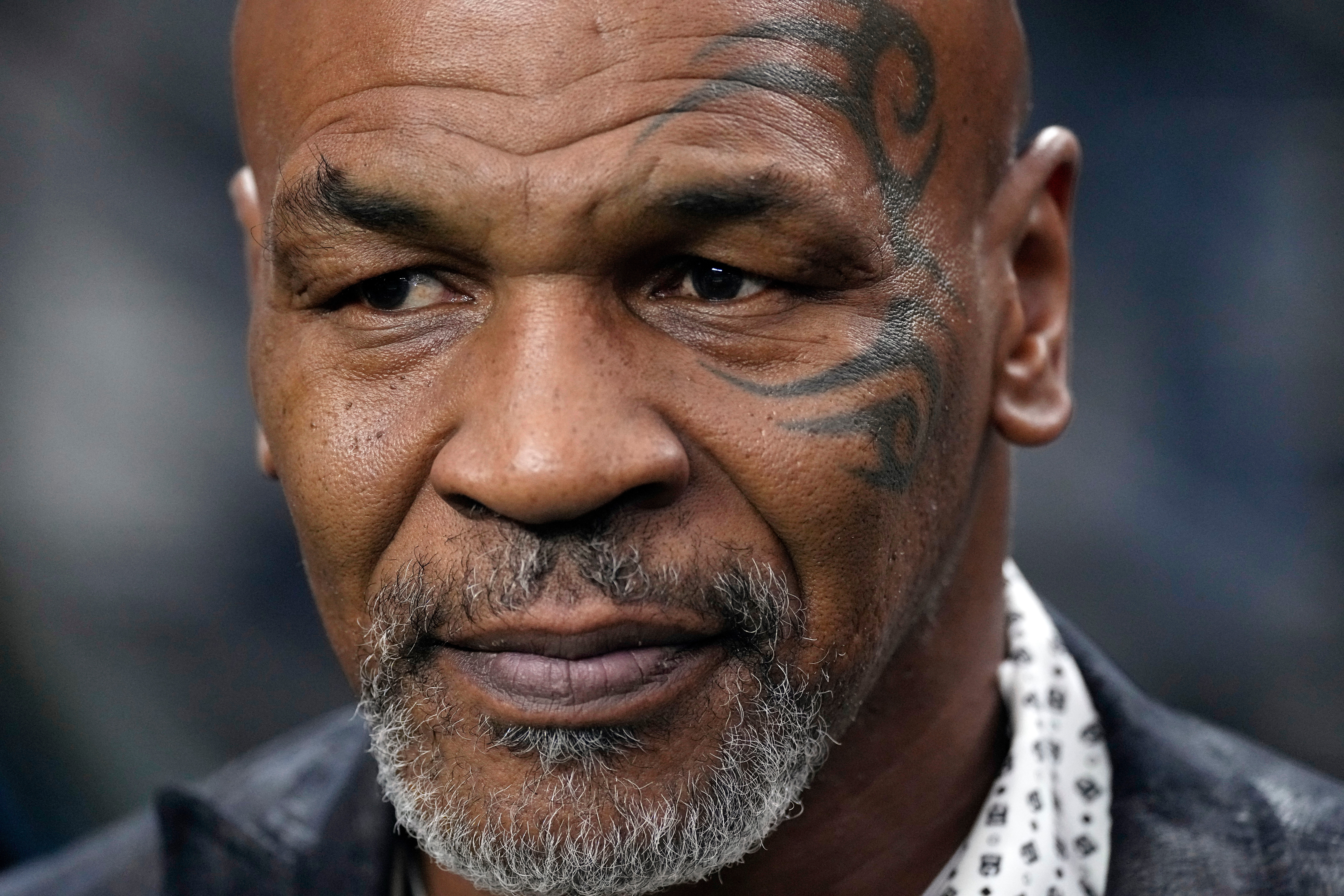 FILE - Former heavyweight boxing champion Mike Tyson stands on the field before an NFL football game between the Las Vegas Raiders and the Pittsburgh Steelers, Sept. 24, 2023, in Las Vegas. 
