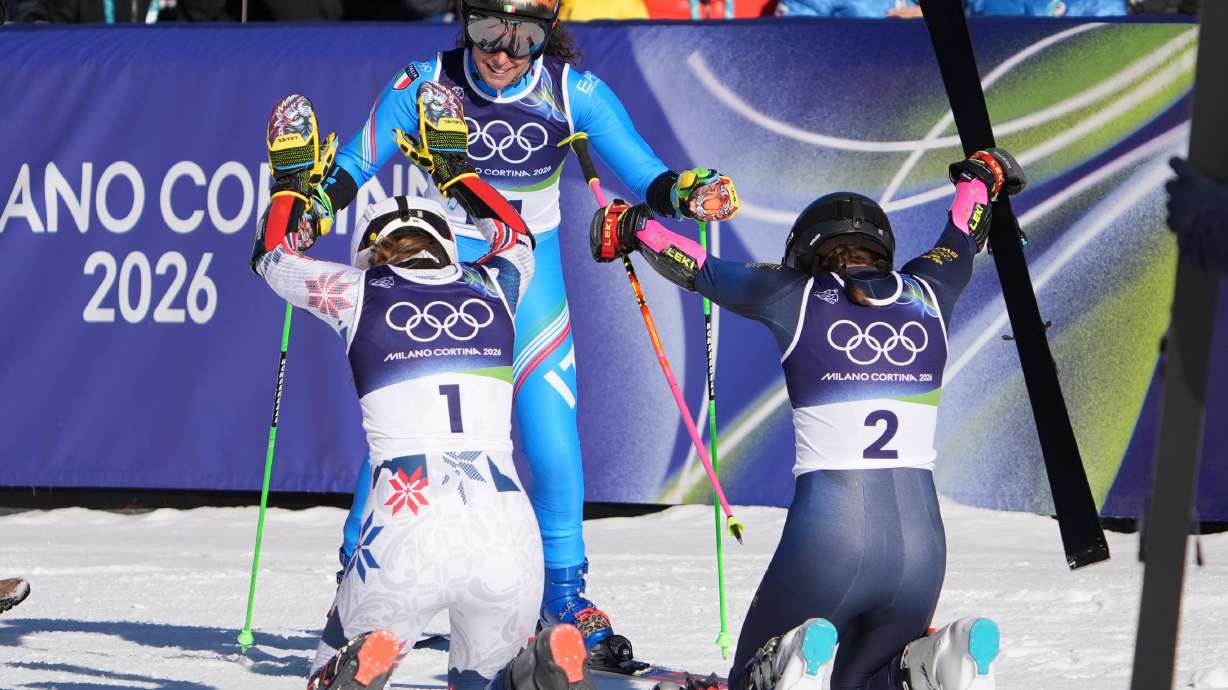 Sweden's Sara Hector, right, and Norway's Thea Louise Stjernesund bow to Italy's Federica Brignone, center, at the finish area of an alpine ski, women's giant slalom race, at the 2026 Winter Olympics, in Cortina d'Ampezzo, Italy, Sunday, Feb. 15, 2026.