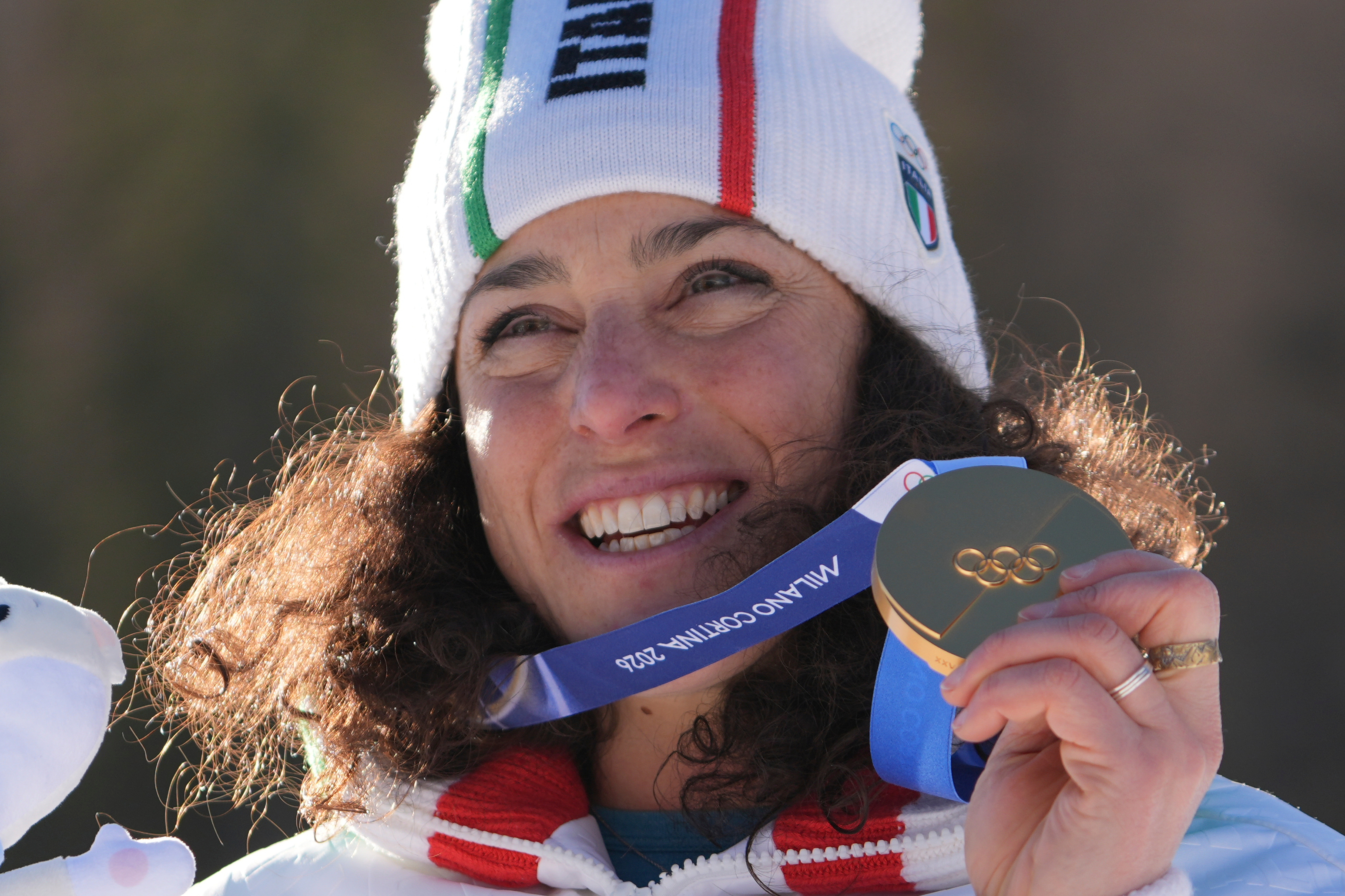 Italy's Federica Brignone shows her gold medal in an alpine ski, women's giant slalom race, at the 2026 Winter Olympics, in Cortina d'Ampezzo, Italy, Sunday, Feb. 15, 2026. 