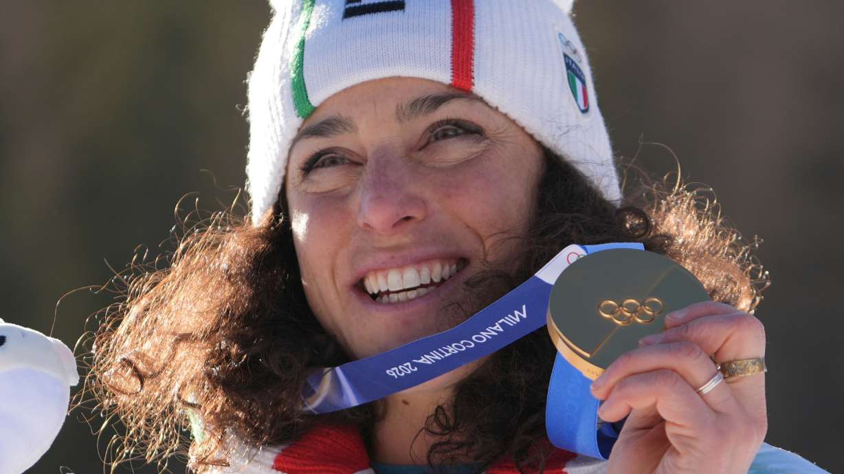 Italy's Federica Brignone shows her gold medal in an alpine ski, women's giant slalom race, at the 2026 Winter Olympics, in Cortina d'Ampezzo, Italy, Sunday, Feb. 15, 2026.