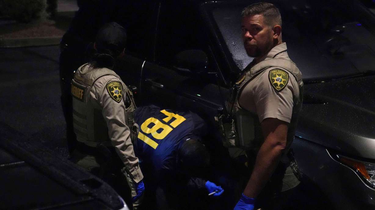Pima County sheriff and FBI work on a Range Rover in a Culver’s parking lot in Tucson, Ariz. early Saturday.