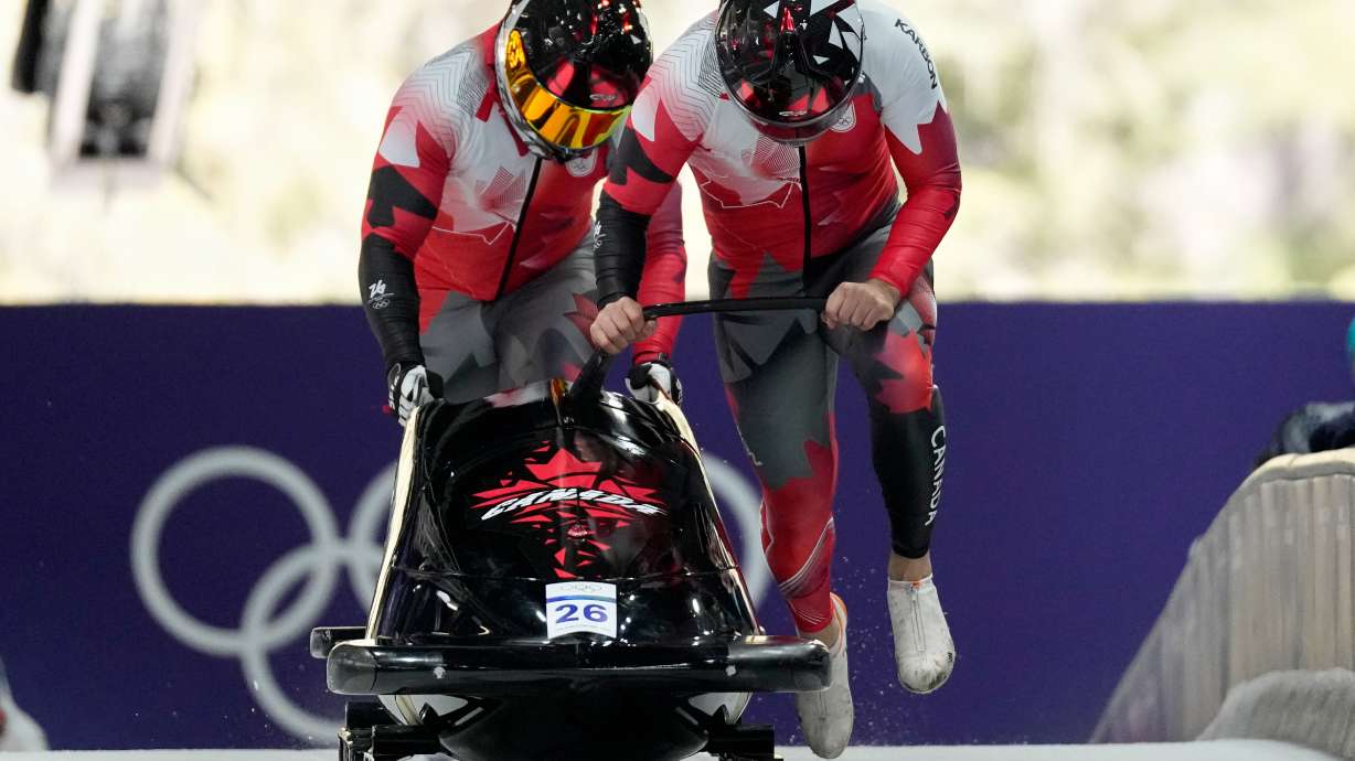 Canada's Taylor Austin, right, and Shaquille Murray-Lawrence start for a two man bobsled run at the 2026 Winter Olympics, in Cortina d'Ampezzo, Italy, Monday, Feb. 16, 2026.
