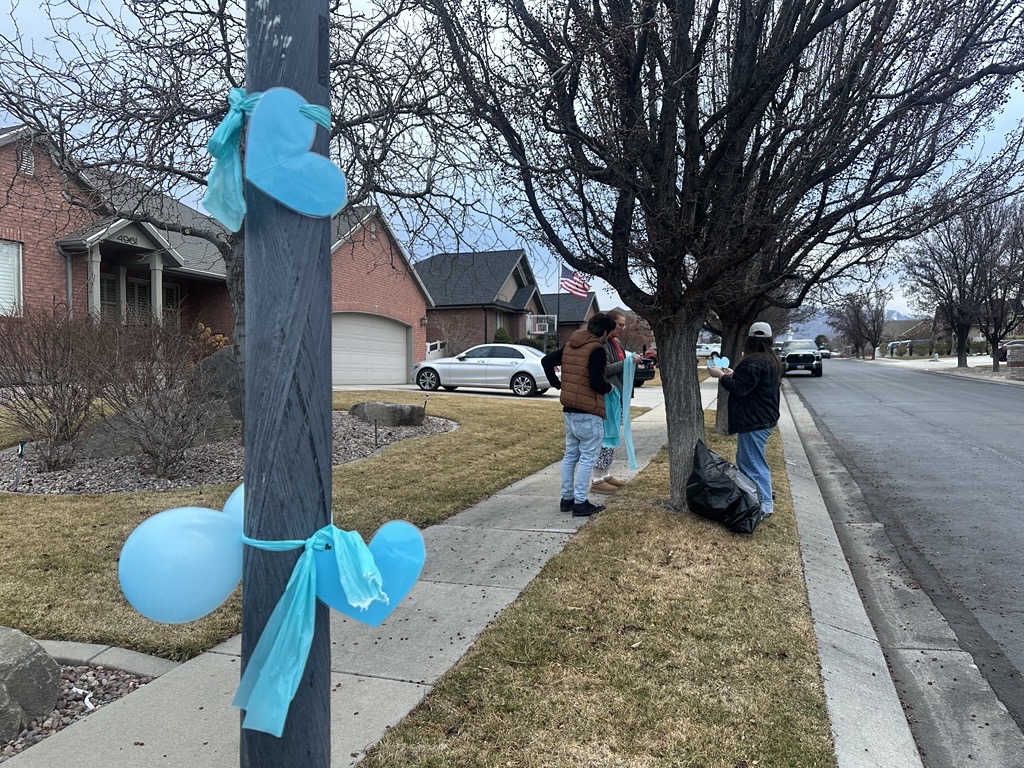 Neighbors tie blue ribbons around trees to show their support for the grieving family of Addi Smith, Monday. Addi was killed in a murder-suicide in Las Vegas, according to police.