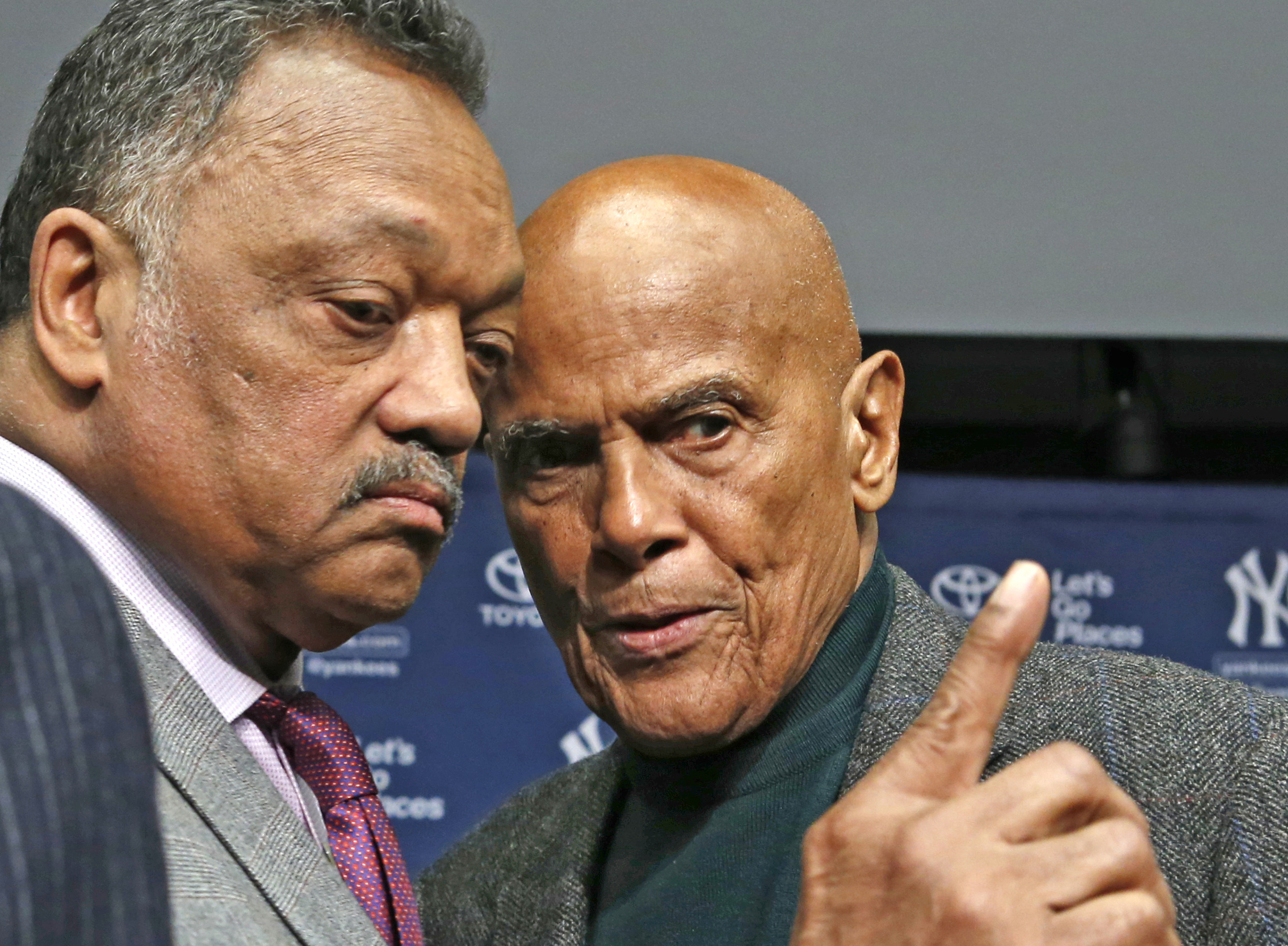 Rev. Jesse Jackson, left, talks with singer and civil right rights activist Harry Belafonte after a news conference announcing the installation of a Nelson Mandela plaque in Yankee Stadium's Monument Park in New York, April 16, 2014.