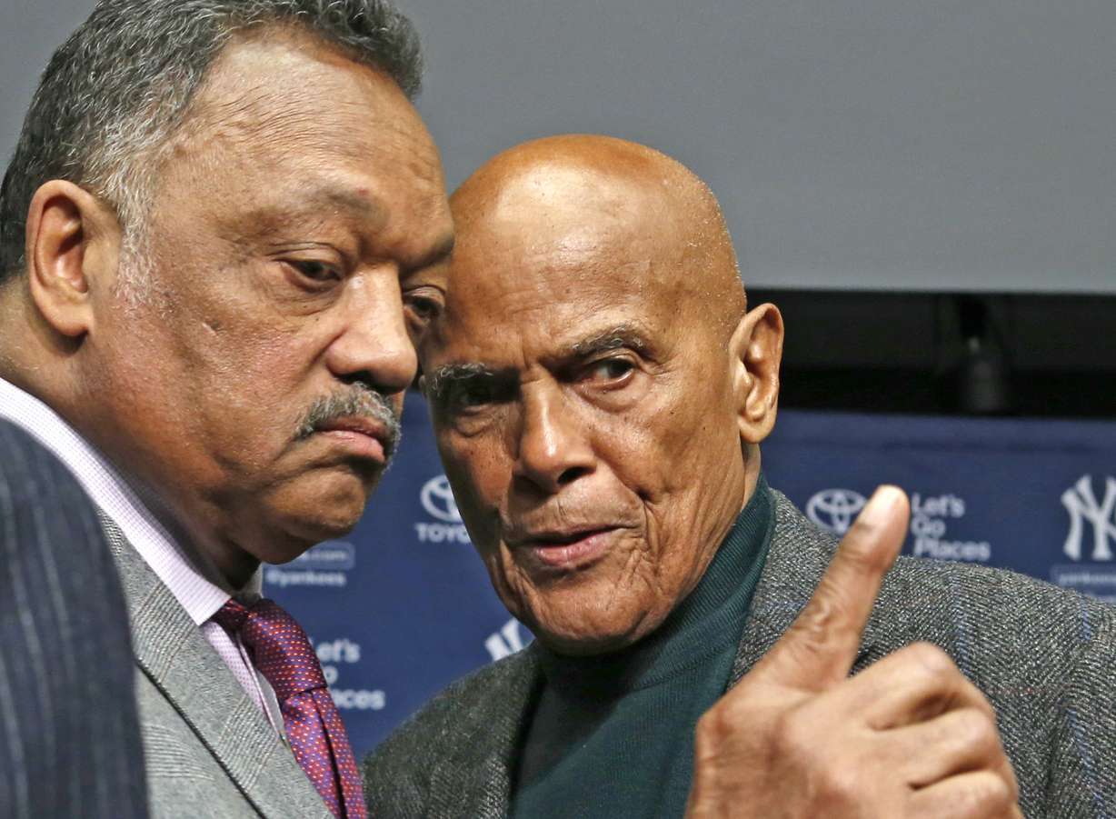 Rev. Jesse Jackson, left, talks with singer and civil right rights activist Harry Belafonte after a news conference announcing the installation of a Nelson Mandela plaque in Yankee Stadium's Monument Park in New York, April 16, 2014.